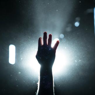 person's hand on light by Kyle Johnson courtesy of Unsplash.