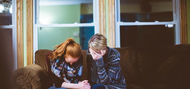 man and woman sitting on sofa in a room by Ben White courtesy of Unsplash.