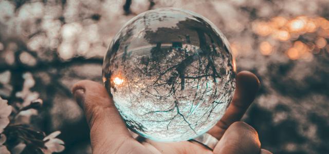 person holding round glass ball by Yeshi Kangrang courtesy of Unsplash.